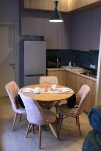 y cocina con mesa, sillas y nevera. en Downtown Apartment en Kutaisi