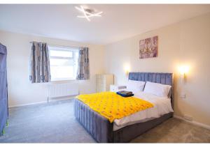 a bedroom with a bed with a yellow blanket at 4 Bedroom Home in Tranquil Gravesend Location in Gravesend