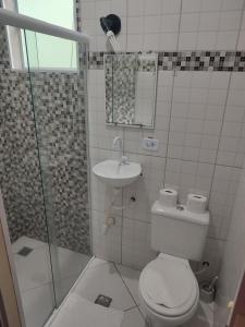 y baño con aseo, lavabo y ducha. en Chalé Canto do Galo, en Ilhabela