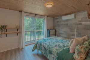 The Phoenix - riverside chalet with beach في مونت تريمبلانت: غرفة نوم بها سرير ونافذة كبيرة