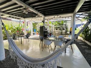 a hammock in a room with a table and chairs at Mahajab Homestay SIARGAO in General Luna
