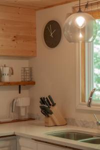 The Phoenix - riverside chalet with beach في مونت تريمبلانت: طاولة مطبخ مع ساعة وكتلة سكاكين