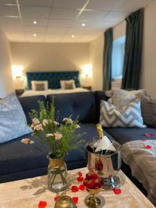 a living room with a blue couch and a table with flowers at Hotell Carl Friman in Motala
