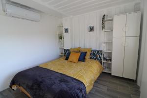 a bedroom with a bed with blue and orange pillows at C'est Chouette les Vosges aux portes de l'Alsace et à proximité de Saint Dié des Vosges in Senones