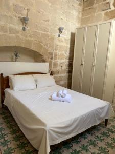 ein Schlafzimmer mit einem Bett mit zwei Handtüchern darauf in der Unterkunft The Gem Farmhouse in Qormi