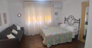 a living room with a bed and a couch at Apart los Lirios in Salta