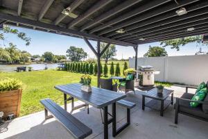a patio with a table and benches and a grill at 2 bedroom Getaway on the River/close to marina in Belle River