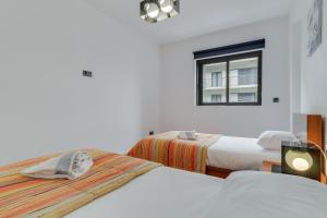 2 bedden in een witte kamer met een raam bij Ramos Apartment by HRM in Funchal