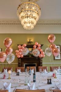 a dining room with a long table with pink balloons at Hotel du Vin Cheltenham in Cheltenham