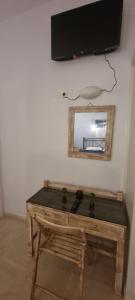 a table with a mirror and a television on a wall at Corfu-Apartments4you in Acharavi