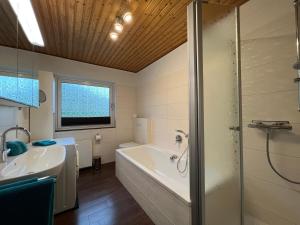 a bathroom with a tub and a shower and a sink at Hof Dalhaus in Lüdinghausen +28 photos