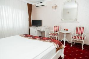 a bedroom with a bed and a desk and a mirror at Hotel Capitol in Iaşi