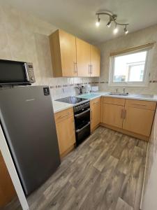 a kitchen with a refrigerator and a sink at Chalet 192, Hemsby - Two bed chalet, sleeps 5, pet friendly, bed linen and towels included in Hemsby