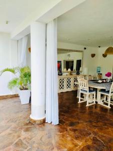 a dining room with a table and chairs at WHITE Nyumba in Malindi