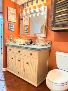 een badkamer met een wastafel, een toilet en een spiegel bij Riverfront condo downtown newbraunfels in New Braunfels