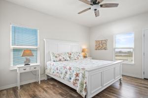 Un dormitorio blanco con una cama y un ventilador de techo. en Turtle Time, en Padre Island 41 fotos más