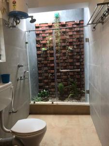 uma casa de banho com WC e uma janela com plantas em Elim-A Sedate Nest em Santiniketan