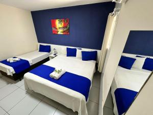 two beds in a room with blue and white at Pousada Costera in João Pessoa