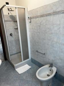 a bathroom with a shower and a toilet and a sink at Appartamento Mira in Cislago