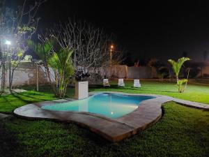 una piscina en un patio por la noche en Hospedaje Campestre Los Suspiros, en Sunampe