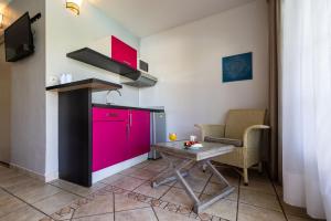 a kitchen with a pink refrigerator and a table at Hôtel Les Créoles in Saint-Gilles les Bains
