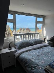 a bedroom with a bed and a large window at Our Place In Portland Holiday Home with Sea View in Portland
