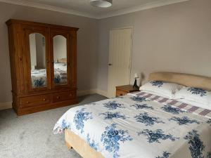 a bedroom with a bed with a dresser and a mirror at Our Place In Portland Holiday Home with Sea View in Portland
