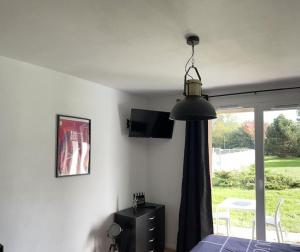 Un dormitorio con una cama y una ventana y una lámpara. en Studio avec piscine près d'Honfleur, en Équemauville