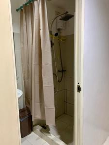 a bathroom with a shower with a shower curtain at Sea Residences - Rylee’s Perfect Place in Manila