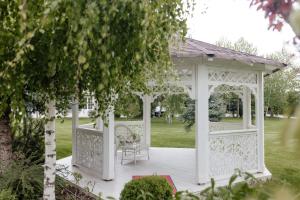 ein weißer Pavillon in der Mitte eines Gartens in der Unterkunft Hotel Capitol in Iaşi