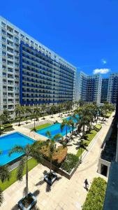 an aerial view of a resort with a pool and palm trees at Sea Residences - Rylee’s Perfect Place in Manila