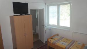 a small room with a tv and a cabinet and a window at Ubytovanie v súkromí Mária Bullová in Žilina
