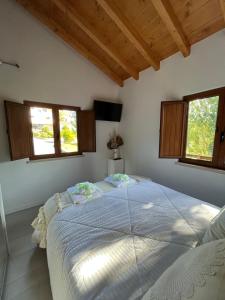 - une chambre avec un grand lit dans une pièce dotée de fenêtres dans l'établissement Casa Gil, Quinta Carmo - Alcobaça/ Nazaré, à Alcobaça