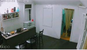 Habitación con bar con sillas y barra. en Comfort BNB en Basseterre