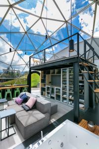 a glass house with a couch and a tub at Mirror Glamping in Sesquilé