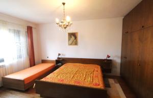 sypialnia z łóżkiem i żyrandolem w obiekcie Apartment Vera w mieście Zambratija