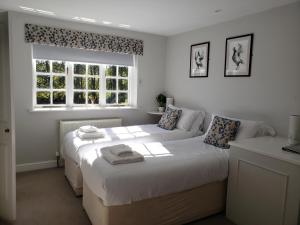 um quarto com 2 camas e uma janela em Watership Down Inn em Whitchurch