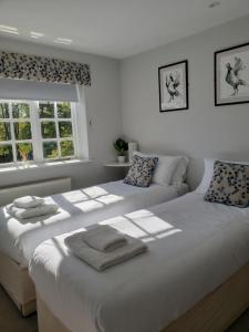 dwa łóżka siedzące obok siebie w sypialni w obiekcie Watership Down Inn w mieście Whitchurch