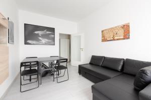 sala de estar con sofá negro y mesa en Apartment with Balcony -Bisceglie Red Line Subway en Milán