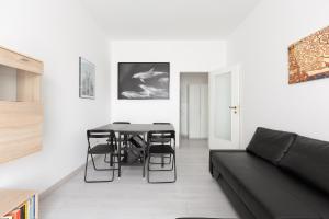 sala de estar con mesa y sofá negro en Apartment with Balcony -Bisceglie Red Line Subway en Milán