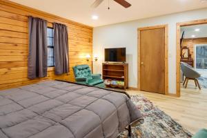 ein Schlafzimmer mit einem Bett, einem Stuhl und einem TV in der Unterkunft Tranquil Creekside Hideout Families Welcome! 