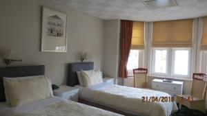 Habitación de hotel con 2 camas y ventana en Hunters Lodge Guest House, en Southampton