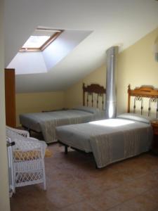 3 camas en una habitación con tragaluz en Hostal Pineda, en Cervera de Pisuerga