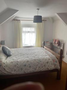 a bedroom with a bed and a window at Myrtle Cottage Boscastle in Boscastle