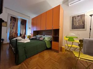 a bedroom with a green bed and a table and cabinets at Casa Milano Expo SP in Milan