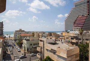 Blick auf eine Stadt mit Gebäuden und das Meer in der Unterkunft 1 Bedroom Suite Yona Hotel in Tel Aviv