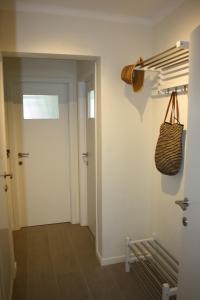 a hallway with a door and a basket on the wall at Prince's165 in Knokke-Heist