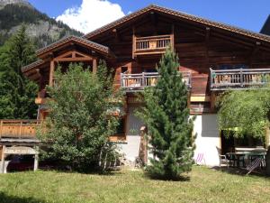 une cabane en rondins avec deux arbres devant elle dans l'établissement Appartement Du Dou Des Ponts, à Pralognan-la-Vanoise