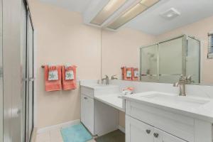 a white bathroom with two sinks and a shower at Naples Paradise Near The Beach! in Naples