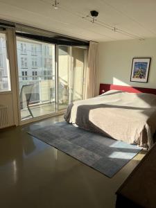 a bedroom with a bed and a large window at Zee en Duin in Cadzand